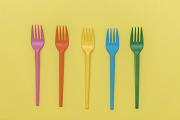 colorful forks on yellow background 