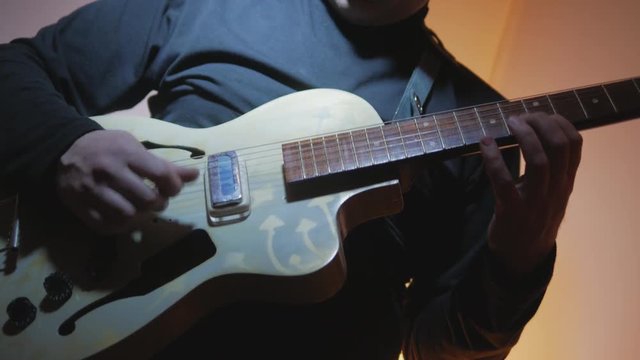 4k Musician playing by vintage guitar during record at the studio