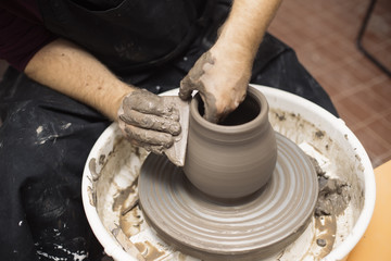 Artist makes clay pottery on a spin wheel