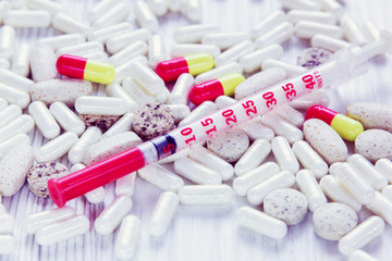 differents pills and insulin syringe
