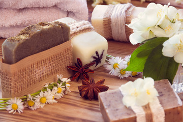 Obraz na płótnie Canvas Decorated pieces of various dry soap with a jasmine, daisy, anises and towel