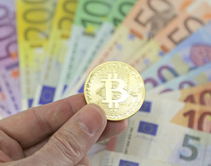 goden BITCOIN and blurred euro banknotes on the background