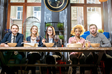 Group of multi ethnic group of business people sitting at the table during the dinner in the modern restaurant