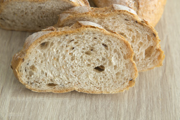 CLOSED UP TWO BROWN SLICED CRUSTY FRENCH BREAD
Two brown sliced crusty french bread on a wood table.