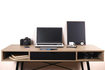 Photo blogger / photographer / it specialist's typical office space table with laptop, blank screen, coffee cup and electronics. Top view, copy space, flat lay, overhead, backdrop.