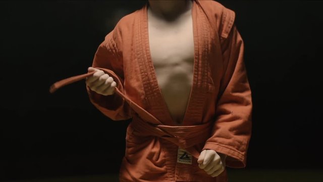 Sportsman boy in a red kimono for judo. Boy puts on a red kimono in preparation for training or sparring