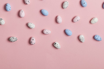 A collection of easter eggs on a pastel pink background
