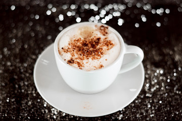 cappuccino on a black surface with bokeh
