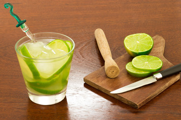A glass of Caipirinha, is the most famous brazilian drink - lemon cachaca and ice - wood board -...