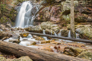 A beautiful waterfall is discovered and flows into a hidden canyon on a Spring day on a mountain.