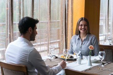 food, christmas, holidays and people concept - smiling couple eating main course at restaurant