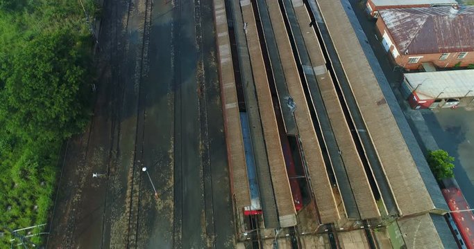 Abandoned rail facility seen from above with rusted train hangars 4K aerial