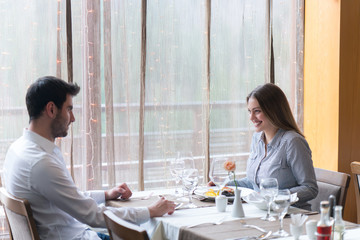 food, christmas, holidays and people concept - smiling couple eating main course at restaurant