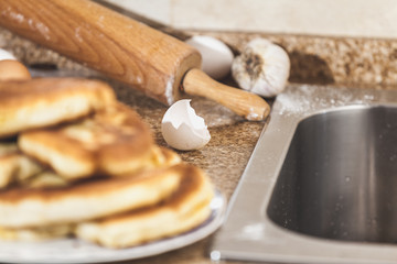shell of broken eggs and rolling pin lying on table