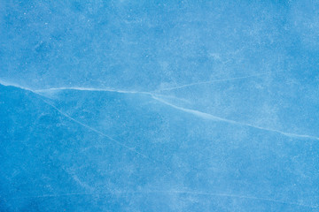 beautiful blue background of ice with cracks and bubbles 