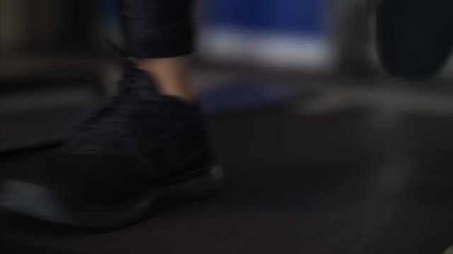 Close up, shoes running on a treadmill and arms pumping, two shot.