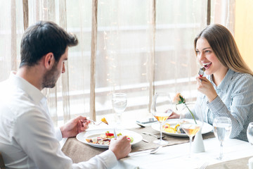 food, christmas, holidays and people concept - smiling couple eating main course at restaurant