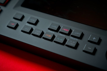 Obraz premium black modern musical instrument, sampler on an intense red background