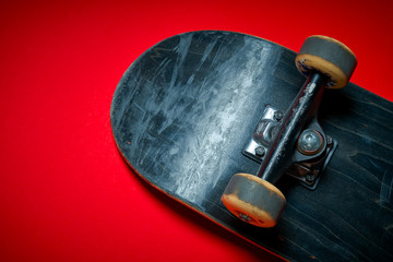 black used skateboard on an intense red background