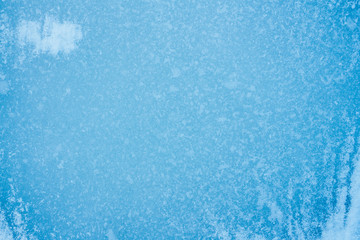 beautiful blue background of ice with cracks and bubbles 