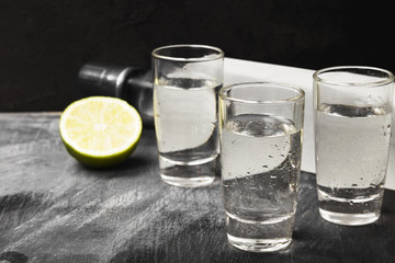 Cold vodka in shot glasses on a black background. Copy space. Food background
