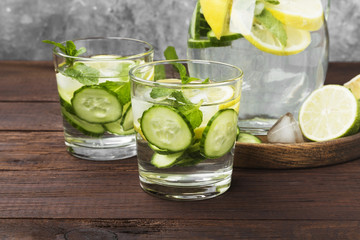 Detox drink with cucumber, lemon and mint in glasses on a wooden background