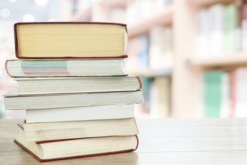 Concept image of education and learning - stocks of books on a desk in the library with copy space.