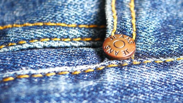 Metal button on jeans close up