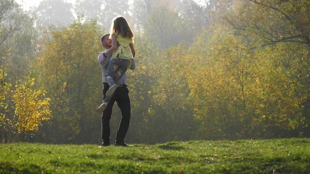 Happy child rushes into hands of father. Father spinning his daughter.