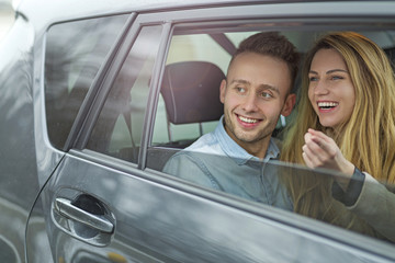 Happy couple sitting in a car
