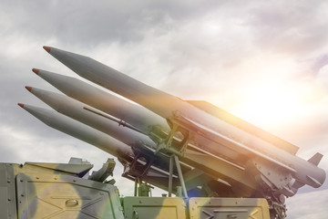 Four rockets are directed upwards against a dramatic sky in the sun. Weapons of mass destruction,...