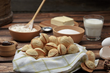homemade cookies shaped nuts with cream boiled condensed milk on wooden table. Rustic style