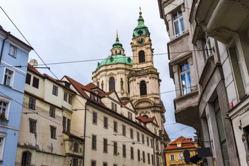 Fototapeta na wymiar Street view in Prague with St.Nicholas Church in the quarter of Mala Strana. Concept of Europe travel, sightseeing and tourism.