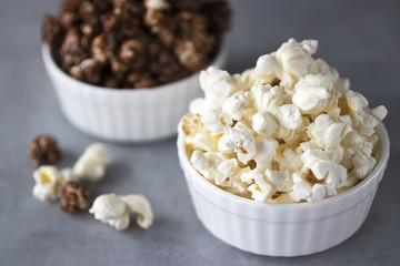 Popcorn in  white bowls on a gray background.