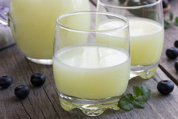 Two glasses of whey with blueberries in the background