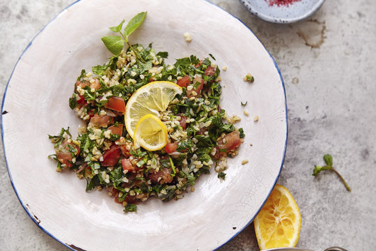Image of traditional jewish and middle eastern food tabouli witn fresh mint, parsley and tomatoes. Israeli cuisine concept