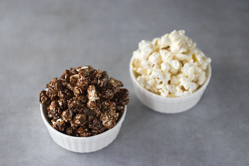 Popcorn in  white bowls on a gray background.