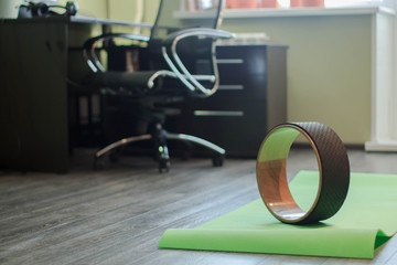 A ring for practicing yoga and a green yoga mat. Yoga in the office.