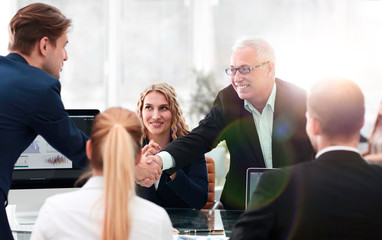 business partners shake hands in the conference room