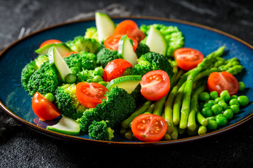 Closeup of salad with broccoli, asparagus and cherry tomatoes