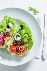 Top view of salad with lettuce, tomatoes and feta cheese