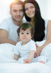 Obraz premium Happy couple and son sitting in bed