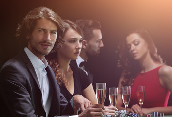 Poker players drink champagne on a black background