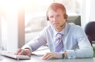 Naklejka premium Happy businessman in headphones smiling while looking at camera.