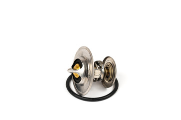 Obraz premium New car thermostat on a white isolated background next to a rubber gasket. Repair kit of spare parts for the replacement of the thermostat in the engine cooling system