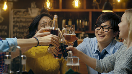 Diverse Group of Beautiful Young People Make a Toast and Clink Raised Glasses with Various Drinks in Celebration.