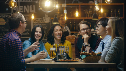 Diverse Group of Young People Have Fun in Bar, Talking, Telling Stories and Jokes. They Drink Various Drinks. They're in the Stylish Hipster Establishment.