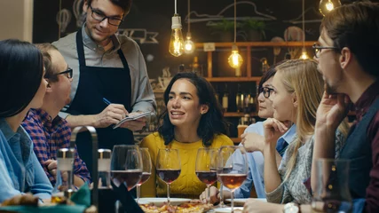 Keuken spatwand met foto In de bar/restaurant neemt de ober de bestelling op van een diverse groep vrienden. Mooie mensen drinken wijn en hebben plezier op deze stijlvolle plek. © Gorodenkoff