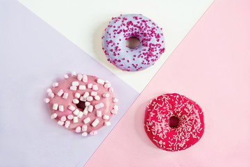 three donuts red pink purple on a three-color background