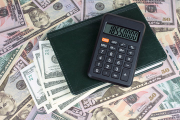 calculator green notebook with dollar bills on the background of money illegally money concept